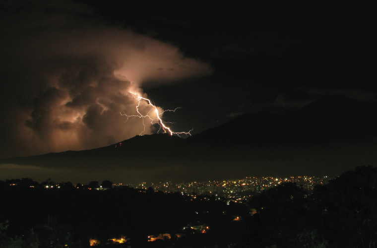 Lighting strikes over a mountain range at night